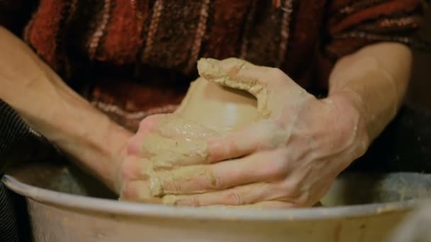 Профессиональный гончар, работающий с глиной на гончарном круге
 - Кадры, видео