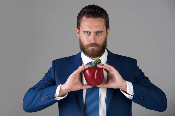 pepper in hand of man with beard holding red vegetable - Fotoğraf, Görsel