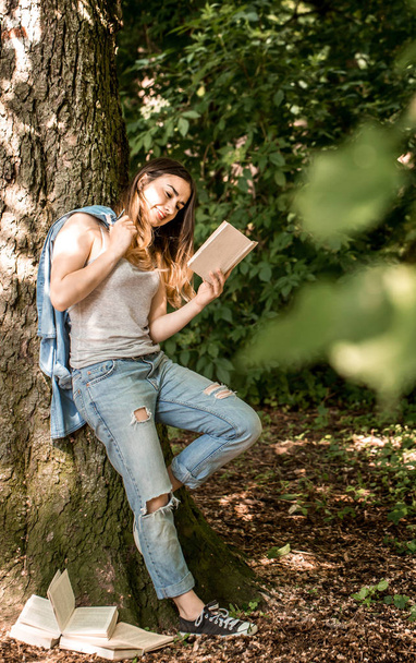 Kız ağaca yakınındaki bir kitap okuma - Fotoğraf, Görsel