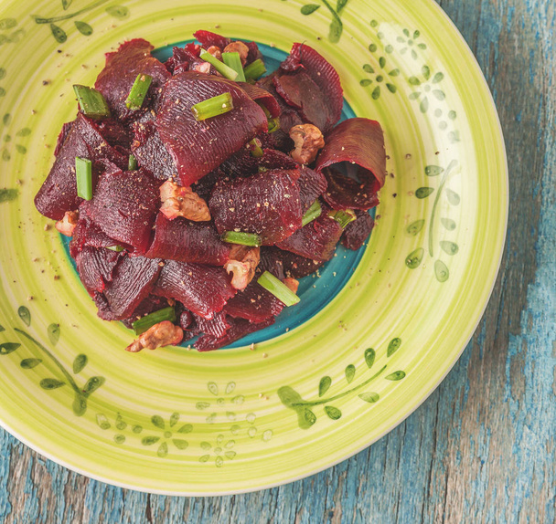 On a bright ethnic plate is a vegetarian lean beet salad, green  - Foto, immagini