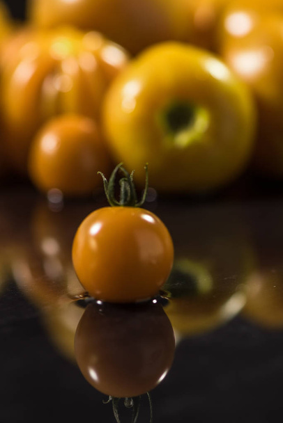 Yellow tomatoes on black background ,water drops ,closeup ,  mirror - Φωτογραφία, εικόνα