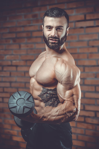 Handsome power athletic man on diet training pumping up muscles - Fotó, kép