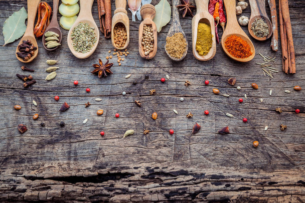 Varie spezie ed erbe aromatiche in cucchiai di legno. Posa piatta di spezie
 - Foto, immagini