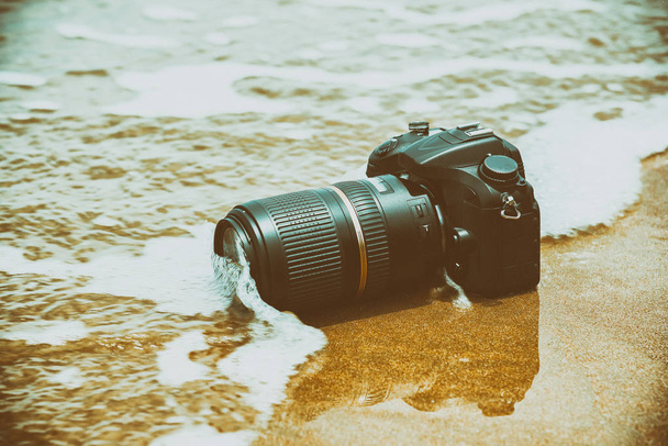 それは海の波から濡れているビーチの上にカメラ - 写真・画像