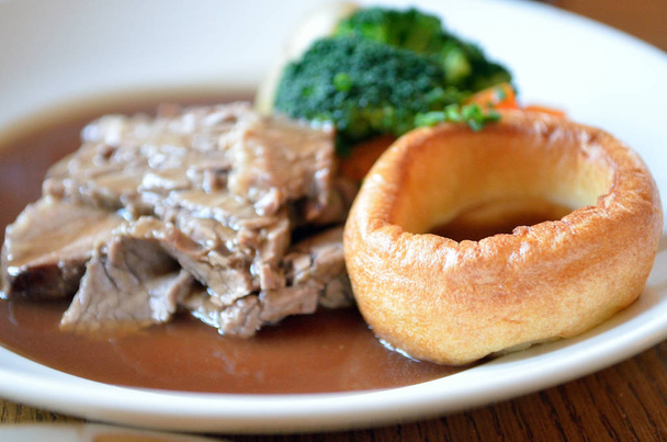 Tradycyjną kolację wołowiny wyprażać niedziela z Yorkshire pudding i sos - Zdjęcie, obraz