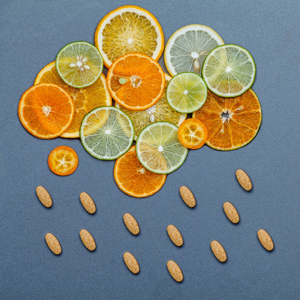 Concepto de alimentos saludables y medicinas. Pastillas de vitamina C y cítricos
 - Foto, imagen