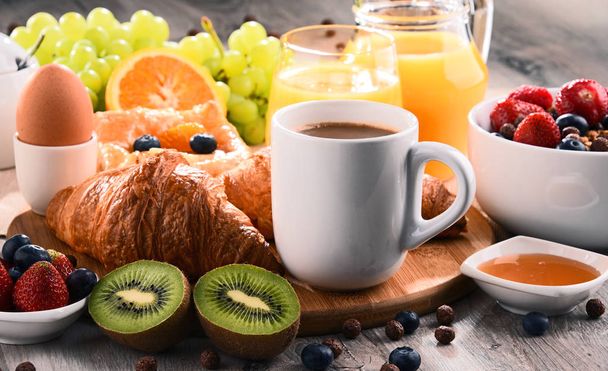 Desayuno servido con café, zumo, croissants y frutas
 - Foto, imagen