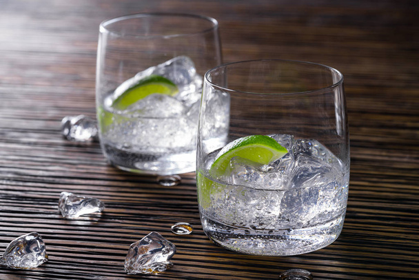Twee glazen met transparante dranken - Foto, afbeelding