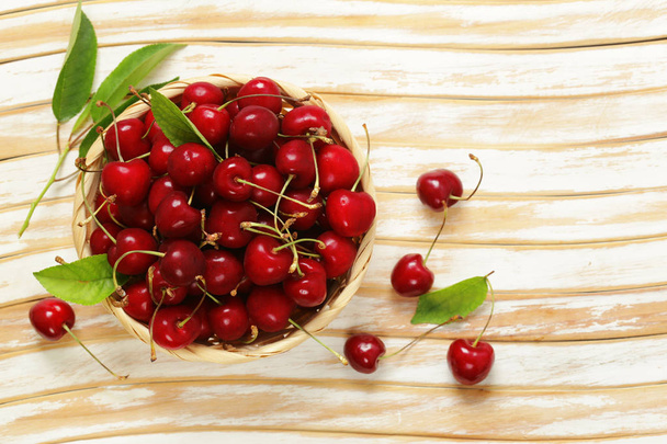 Ripe organic cherry with green leaves - Фото, изображение