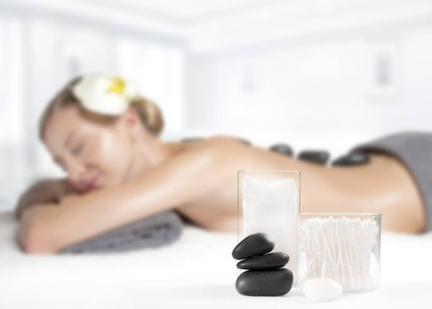 Stone massage. Beautiful woman getting hot stones massage in spa  - Photo, image