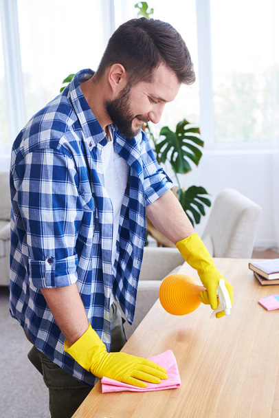 Ihastuttava mies jauhaminen ja pölyäminen työpaikalla
 - Valokuva, kuva