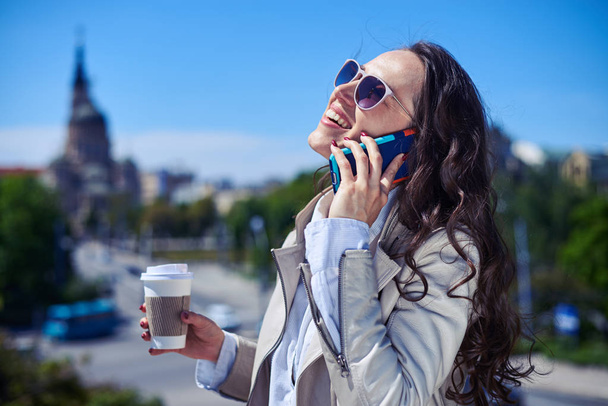 Όμορφο θηλυκό μιλάμε στο τηλέφωνο ενώ πίνουν καφέ - Φωτογραφία, εικόνα