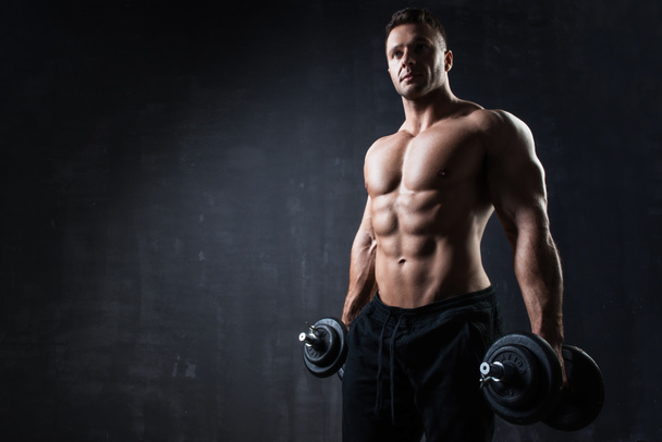 Handsome muscular bodybuilder showing his muscles.  - Foto, Imagen