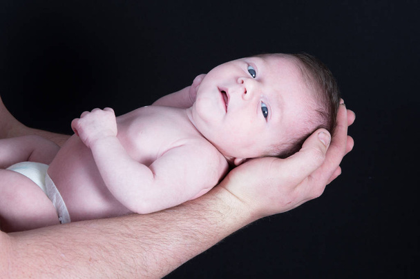 bebê recém-nascido filho deitado no braço pai
 - Foto, Imagem