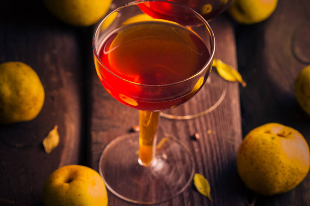 cup tincture wooden table fruits quince - Foto, imagen