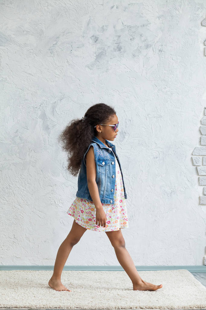 Cute afro girl against the gray wall - Foto, imagen