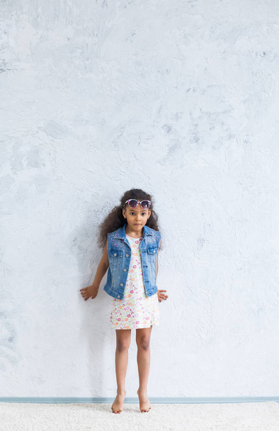 Aranyos afro lány ellen a szürke falon - Fotó, kép