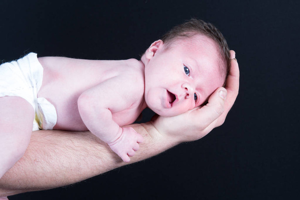 dans le bras papa nouveau-né bébé nu dans le canapé
 - Photo, image