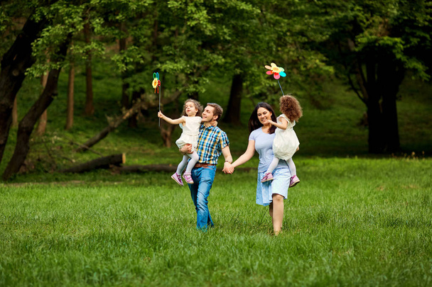 Happy family walking in summer park - Фото, зображення