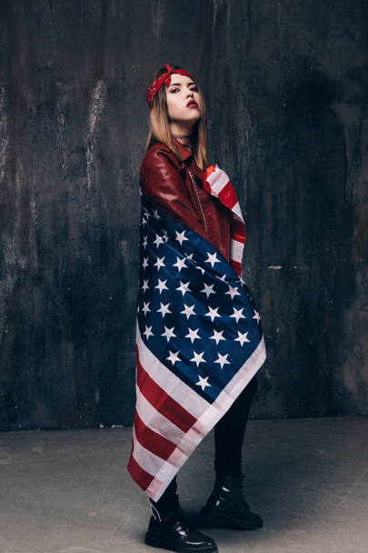 Girl covered by american flag on dark background - Фото, зображення
