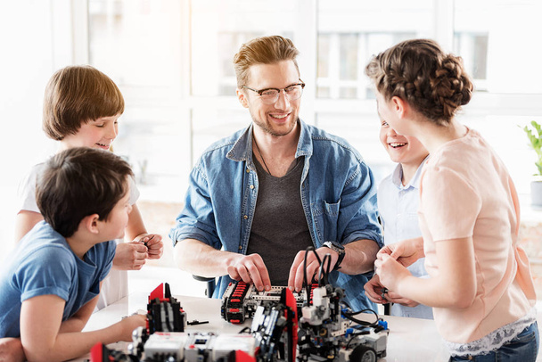 Cheerful male technician having conversation with kids - Photo, Image