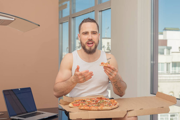 Pizza. A guy with a beard eats pizza - Foto, Imagem