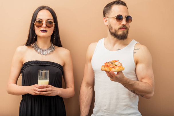 A girl drinks milk, and a guy eats pizza - Photo, image
