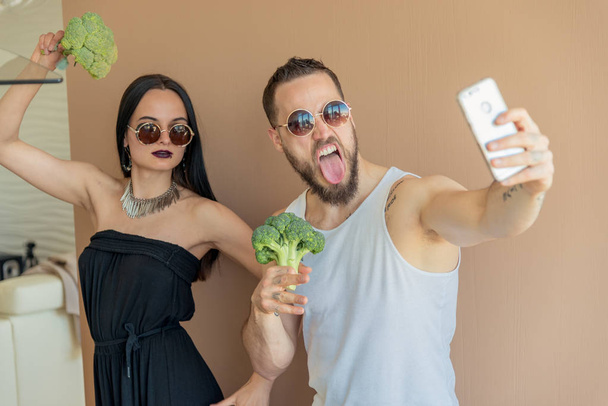 Un chico y una chica con brócoli hacen selfies
 - Foto, imagen