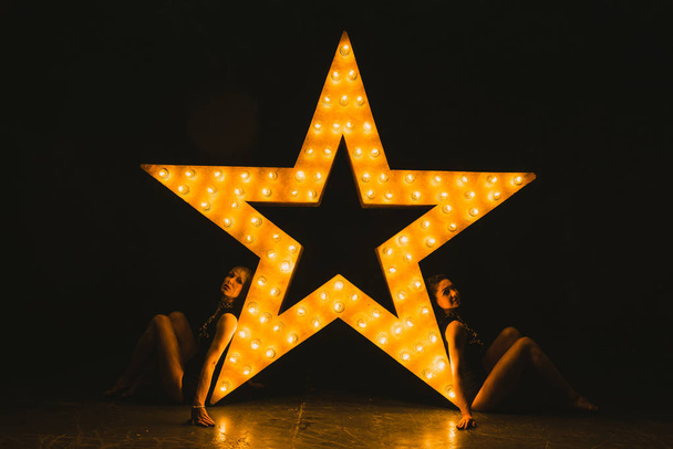 Girls dance against the backdrop of a glowing star - Photo, Image