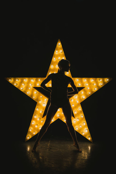 The girl is dancing against the backdrop of a glowing star - Φωτογραφία, εικόνα