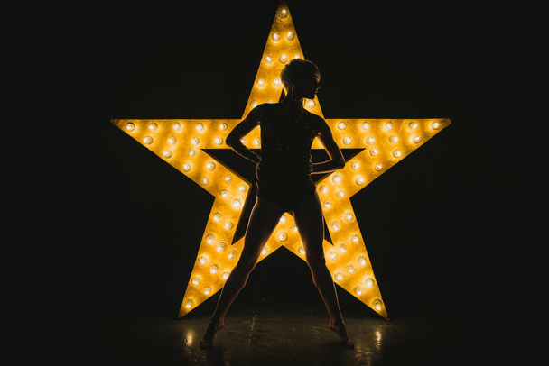 The girl is dancing against the backdrop of a glowing star - Photo, Image