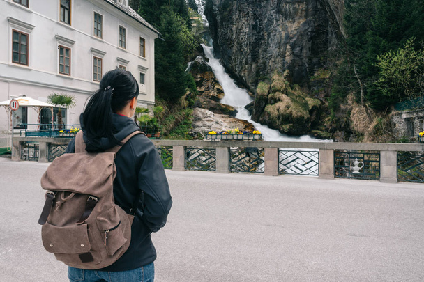 Austria. Bad Gastein. Girl traveler with a backpack near the Alpine falls - Photo, Image