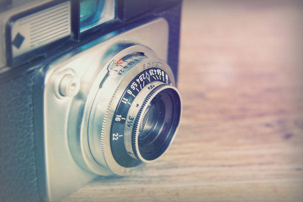 Oude vintage retro camera op houten achtergrond - Foto, afbeelding