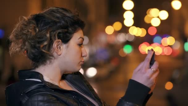 Uroczy brunetka strzela śmieszne selfie, Miasto nocy w tle - Materiał filmowy, wideo