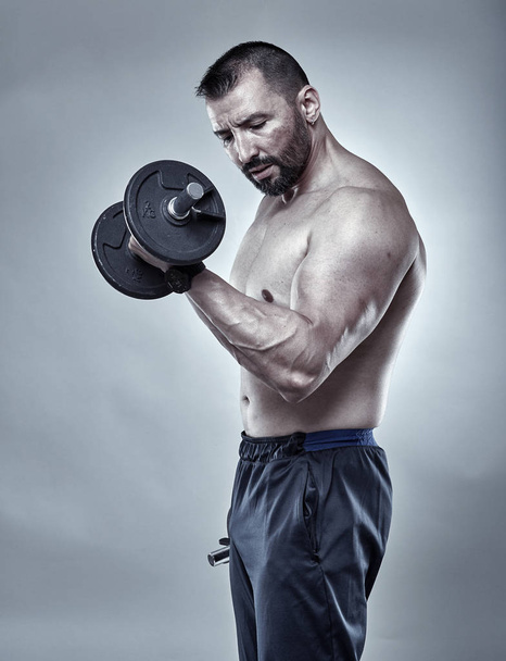Fitness trainer doing biceps workout - Fotó, kép