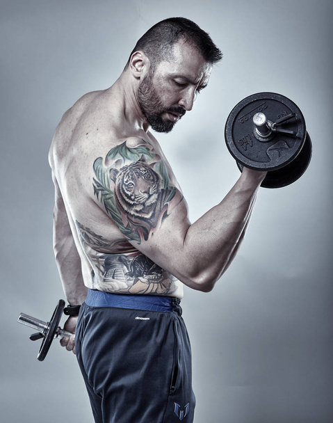 Fitness trainer doing biceps workout - Foto, imagen