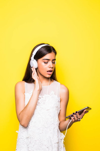 Young beautiful woman with headphones on yellow - Foto, Imagen
