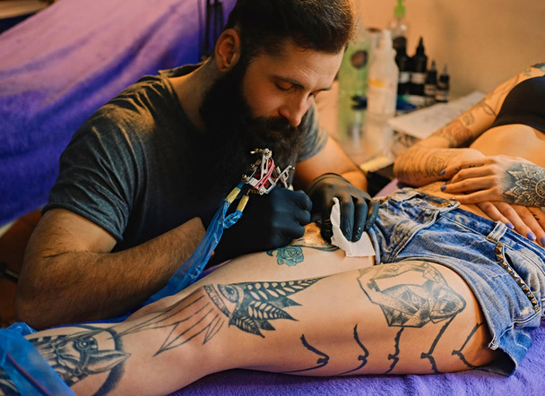 Αρσενικός καλλιτέχνης τατουάζ κάνει μια δερματοστιξία - Φωτογραφία, εικόνα