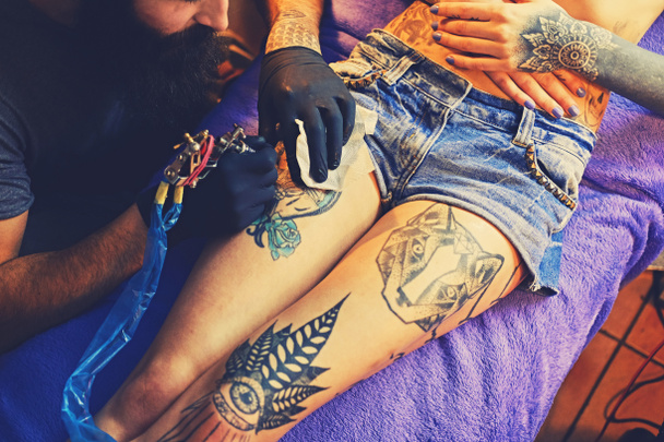Barbudo artista del tatuaje hace un tatuaje
 - Foto, Imagen