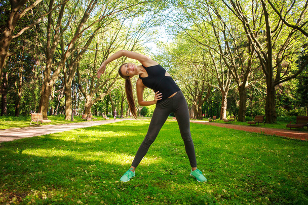 Young woman doing fitness exercises in park - Foto, immagini