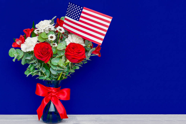 Beautiful bouquet with american flag on blue background - Photo, Image