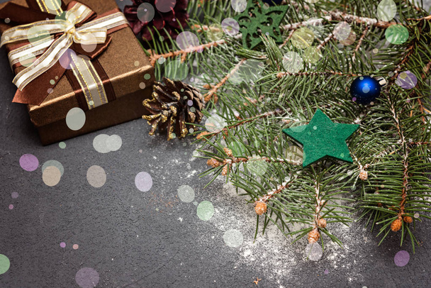 Decoración navideña, ramas de abeto y regalo sobre fondo oscuro. Enfoque selectivo
 - Foto, Imagen