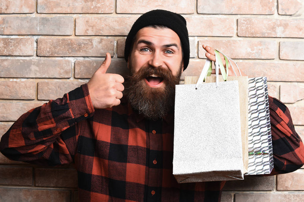 Bearded brutal caucasian hipster with moustache holding shopping packages - Fotografie, Obrázek