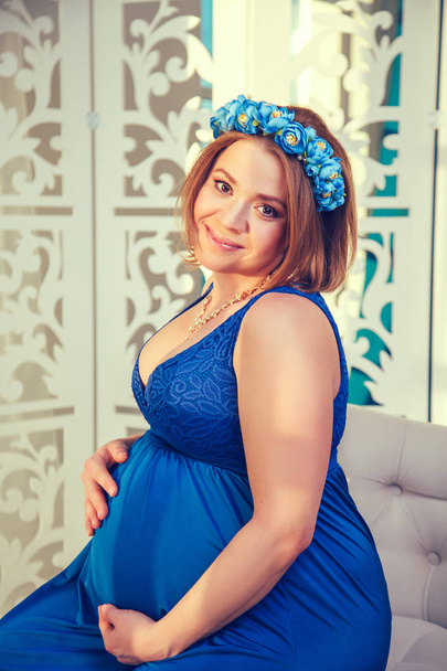 Beautiful pregnant woman in a blue dress. - Foto, imagen