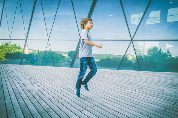 Niño saltando y corriendo en la ciudad
 - Foto, imagen