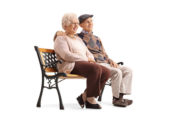 Senior couple sitting on a bench and looking away - Φωτογραφία, εικόνα