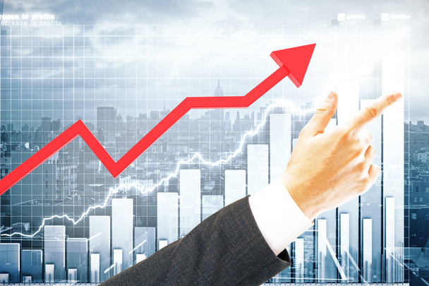 Red chart arrow and pointing businessman's hand on city with business chart background. Finance concept - Fotoğraf, Görsel