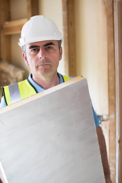 Portrait Of Builder Fitting Insulation Boards Into Roof Of New H - Φωτογραφία, εικόνα
