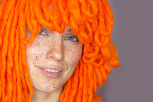 Young funny redhair woman with funny big knits wool wig - Fotó, kép