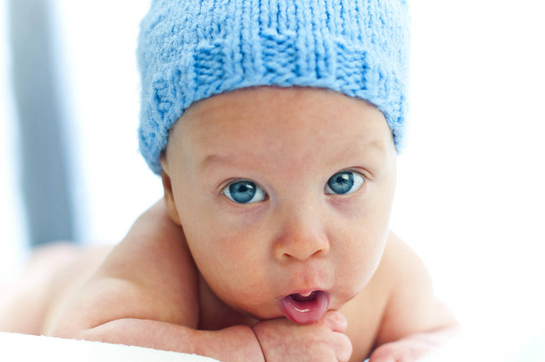 ένα παιδί με τα μπλε μάτια στο καπέλο. Τα μεγάλα μπλε μάτια. Μωρό χαριτωμένο μπλε μάτια. Μάτια γεμάτα ευτυχία. Ευτυχισμένο μωρό μάτια. - Φωτογραφία, εικόνα